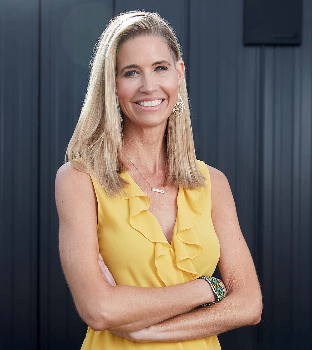 Dr. Amy Killen in a yellow dress, smiling for the camera.