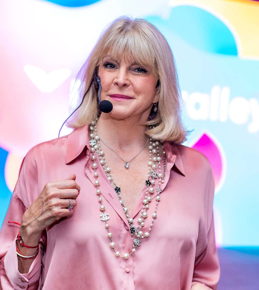 Marisa Peer auf der Bühne mit einer pinken Bluse