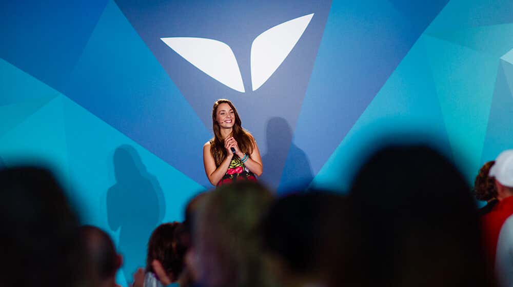Cecilia Sardeo on a stage at Mindvalley Event