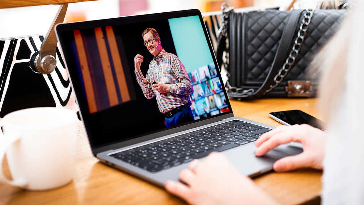 A person holding a tablet watching a virtual event of Vishen