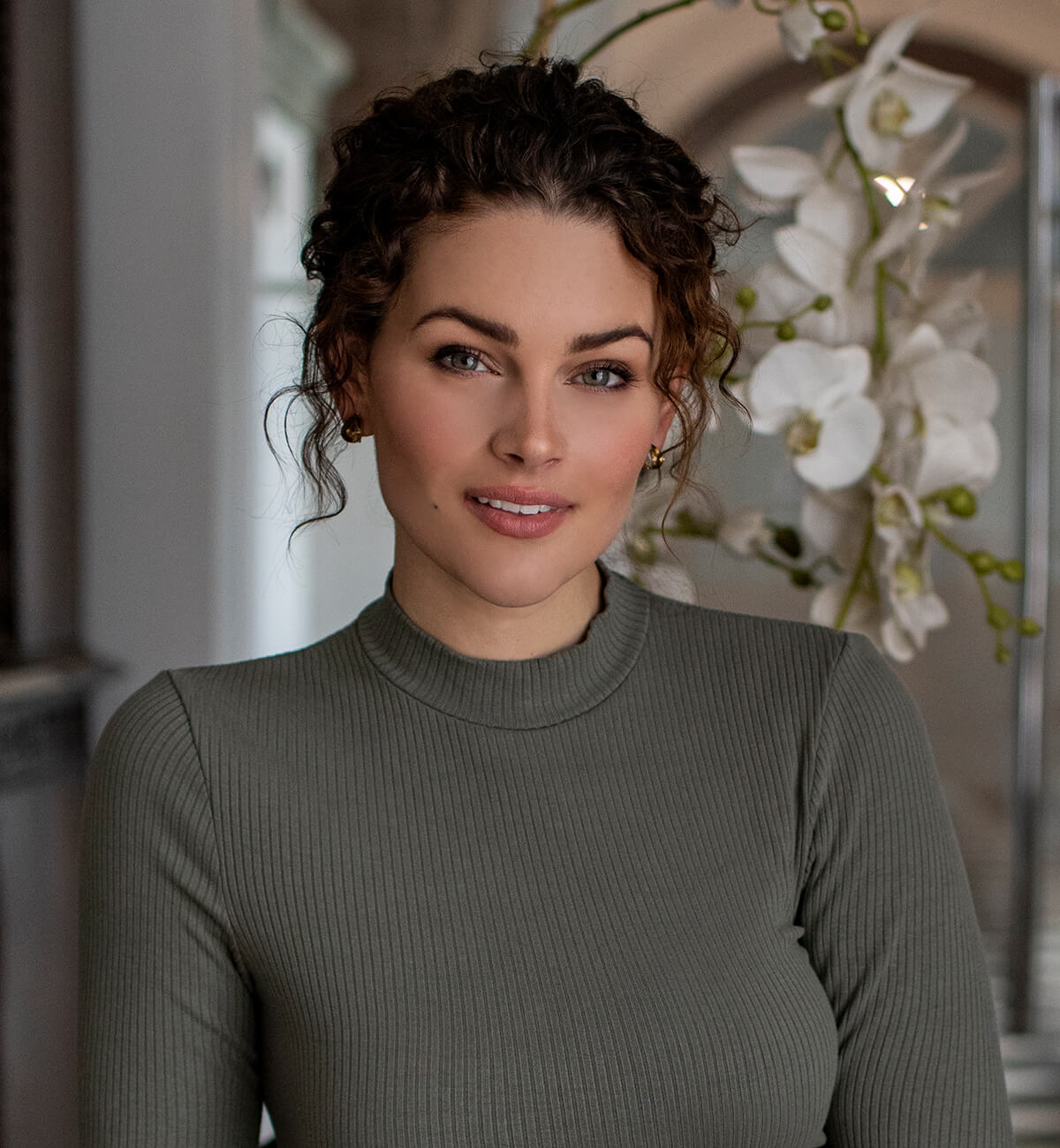 Rolene wearing a sage colored mock neck.