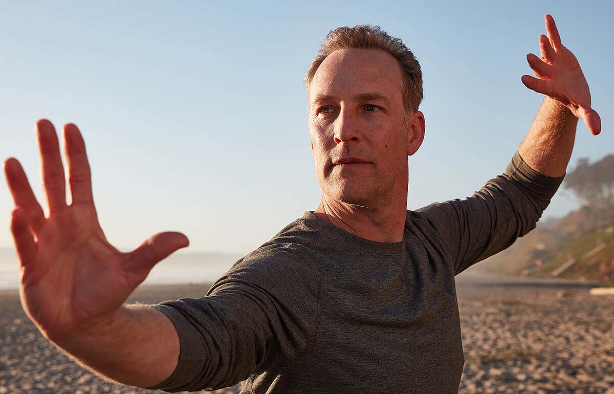 A closeup Lee Holden demonstrating a Qi Gong stance at the beach