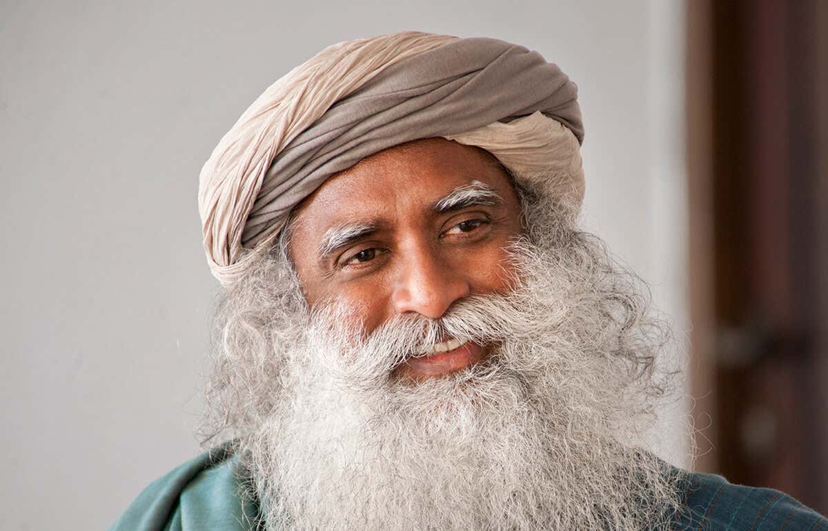 A headshot of Sadhguru looking away, smiliing