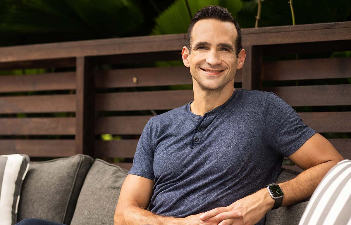Nir Eyal sitting on a sofa, smiling.