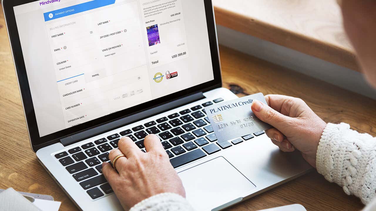 Laptop screen showing a woman holding a credit card to make payment
