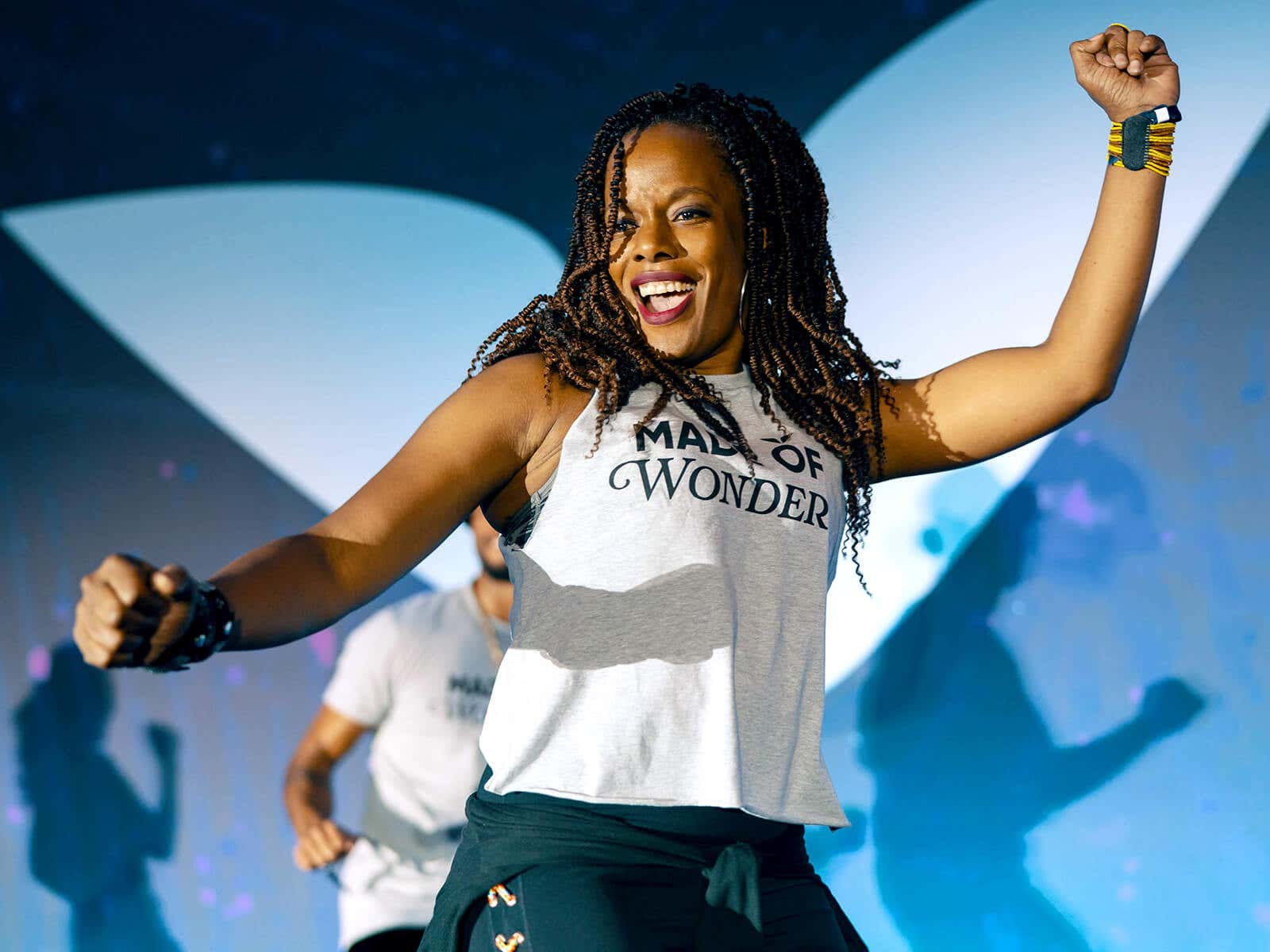 A woman dancing happily on stage at Mindvalley event
