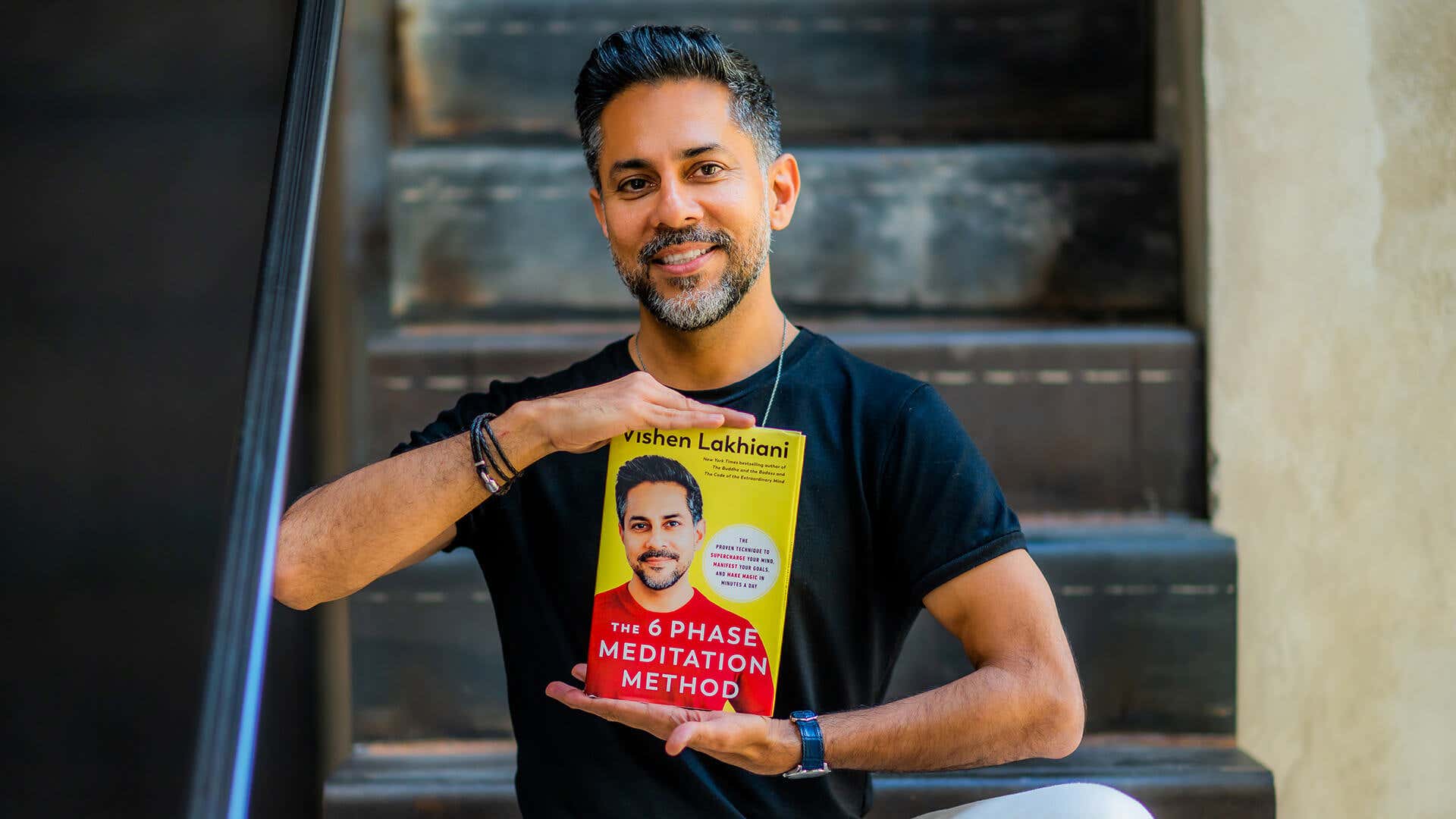 Vishen holding his book The 6 Phase Meditation Method