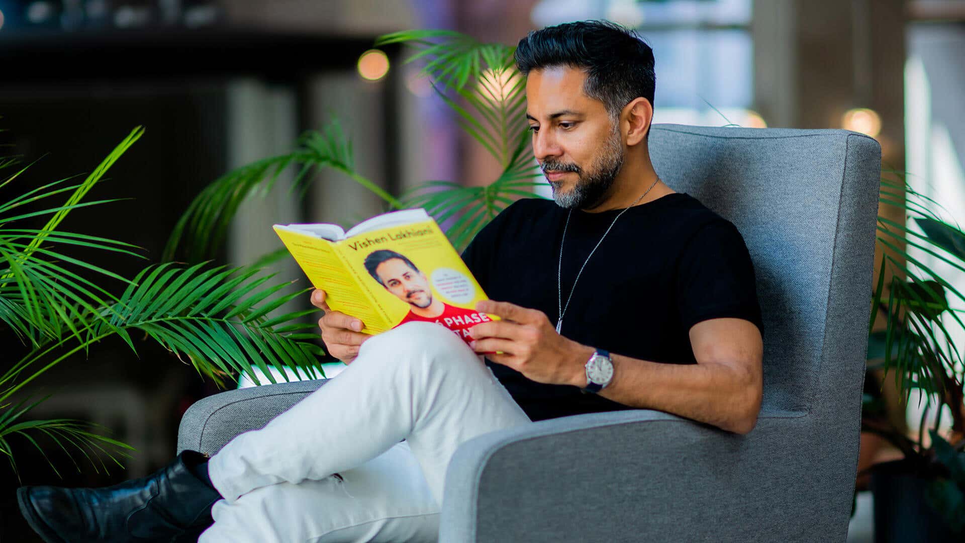 Vishen reading his book on a chair