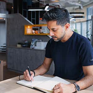 Vishen writing on a journal