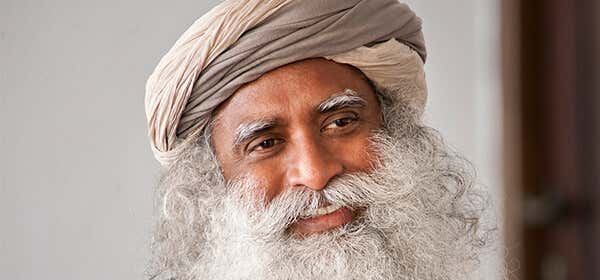 A headshot of Sadhguru looking away, smiliing