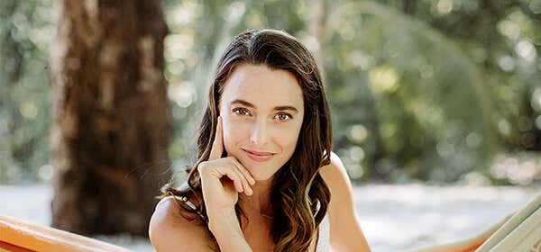 Jennifer Partridge resting her chin on her hands while sitting and smiling.