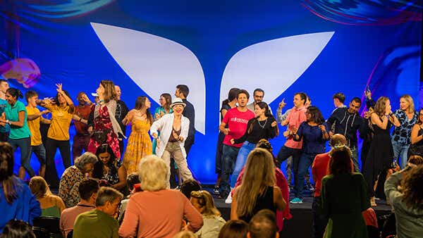 Mindvalley members dancing on stage in Mindvalley event