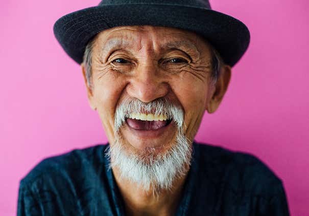 Senior asian man with hat and sunglasses smiling