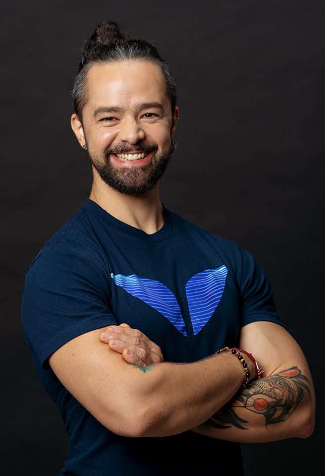 Ronan con los brazos cruzados en un fondo oscuro