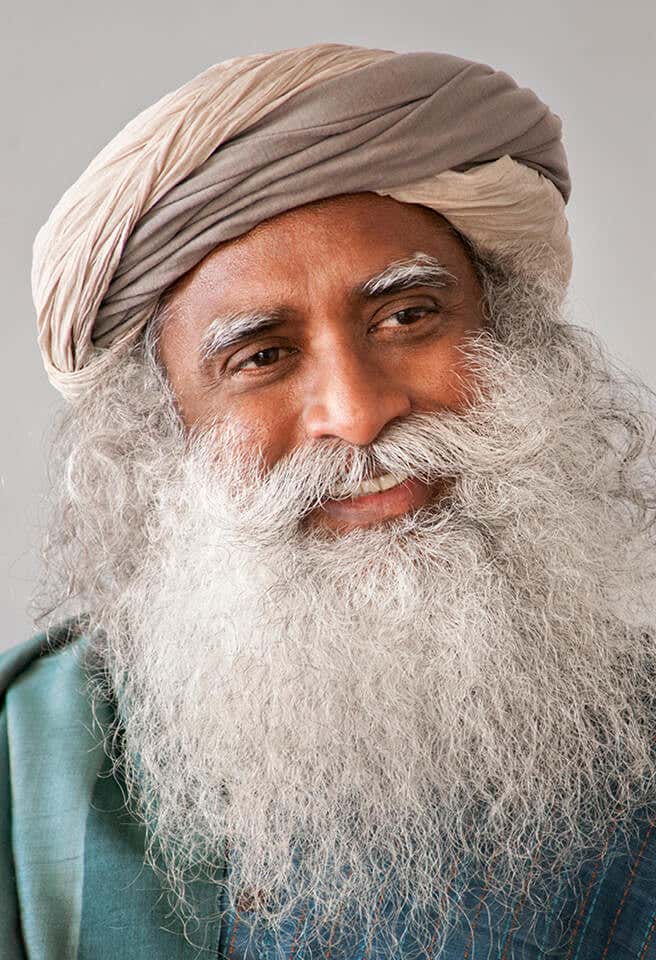 A headshot of Sadhguru looking away, smiliing