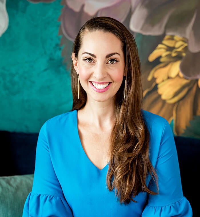 Vanessa wearing a turquoise blouse, smiling.