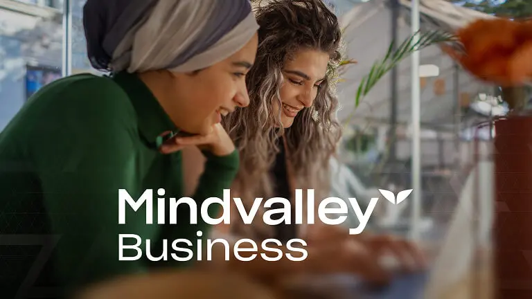 Mindvalley event stage featuring a speaker and audience with hands up