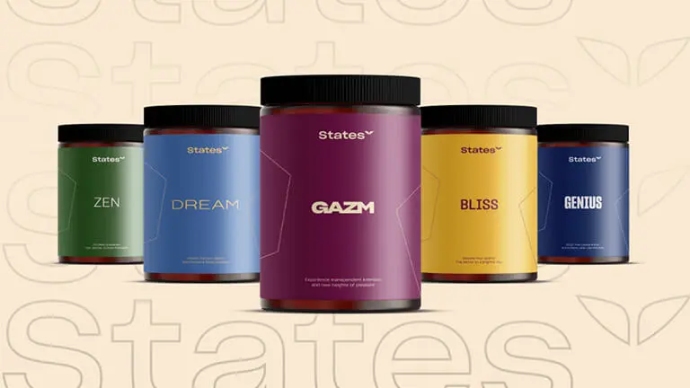 Mindvalley event stage featuring a speaker and audience with hands up