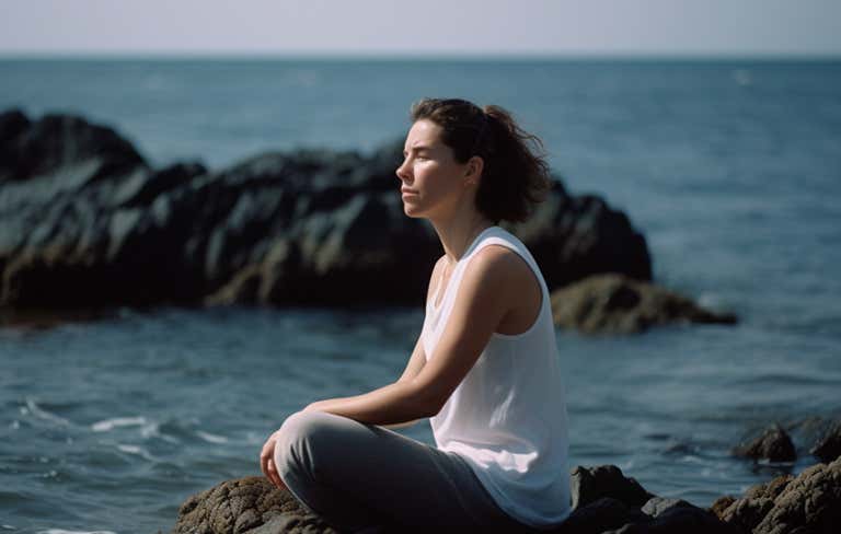 A woman sitting by the sea